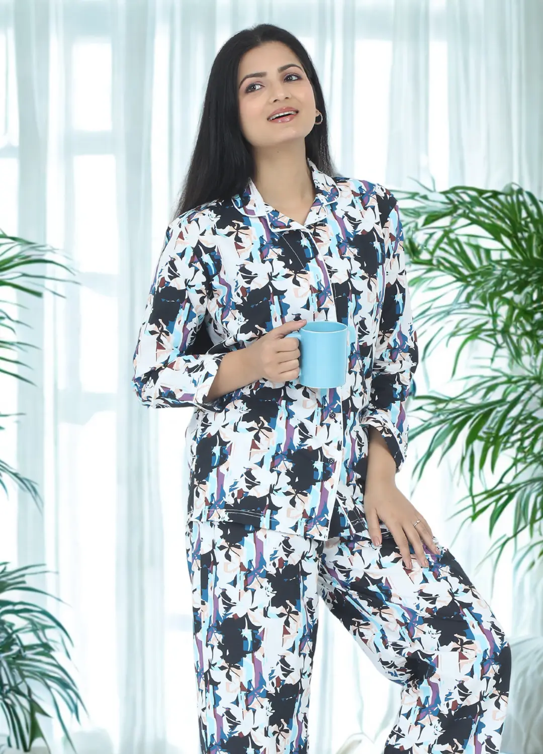 Babudu Model wearing -Petals play 3 piece 100% cotton Sleepwear and pyjama set- featuring a button-down top, pants, and shorts for a relaxed fit -there are plants on the sides banner