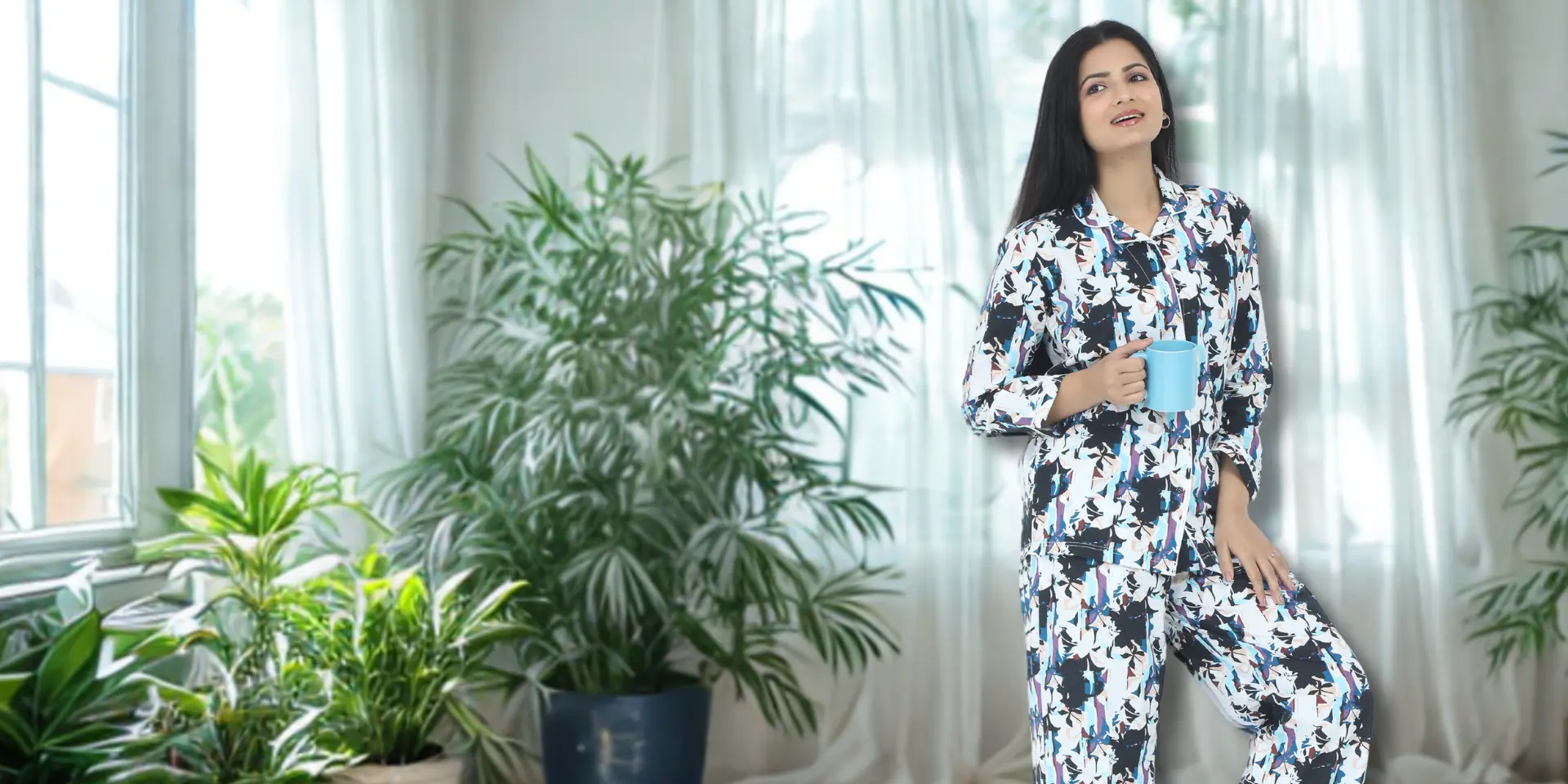 Babudu Model wearing -Petals play 3 piece 100% cotton Sleepwear and pyjama set- featuring a button-down top, pants, and shorts for a relaxed fit -there are plants on the sides banner