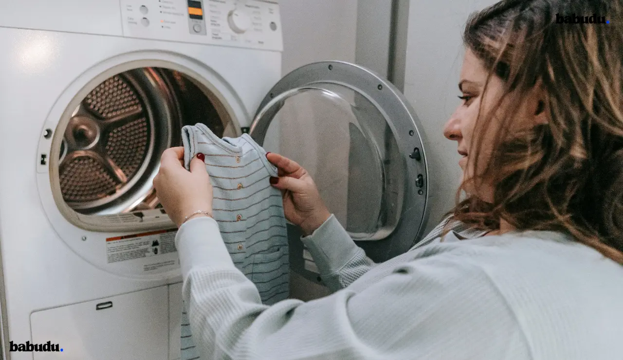 Hands demonstrating pre-wash sleepwear care routine checking for stains and preparing items
